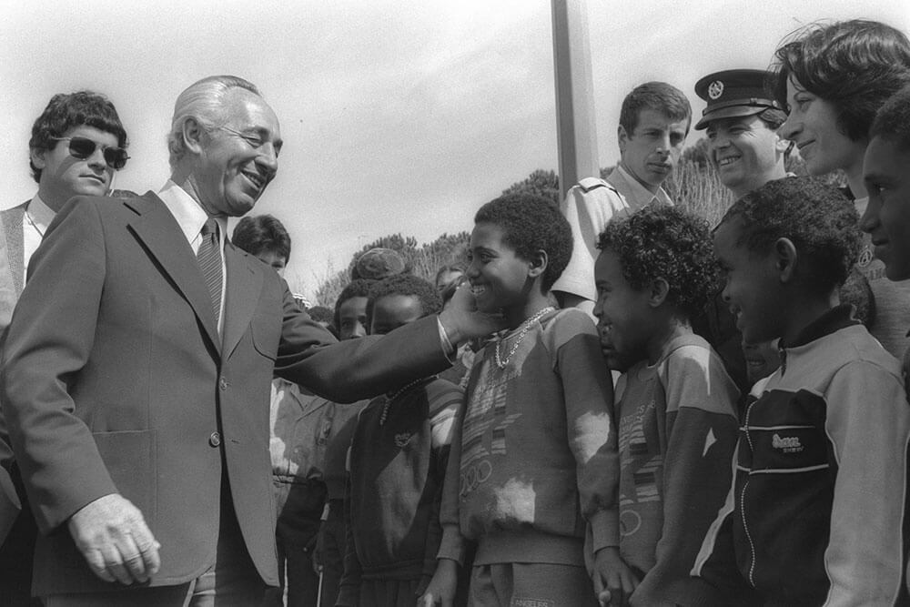  Shimon Perez posiert mit einem äthiopischen Kind, 1985. Foto: GPO
