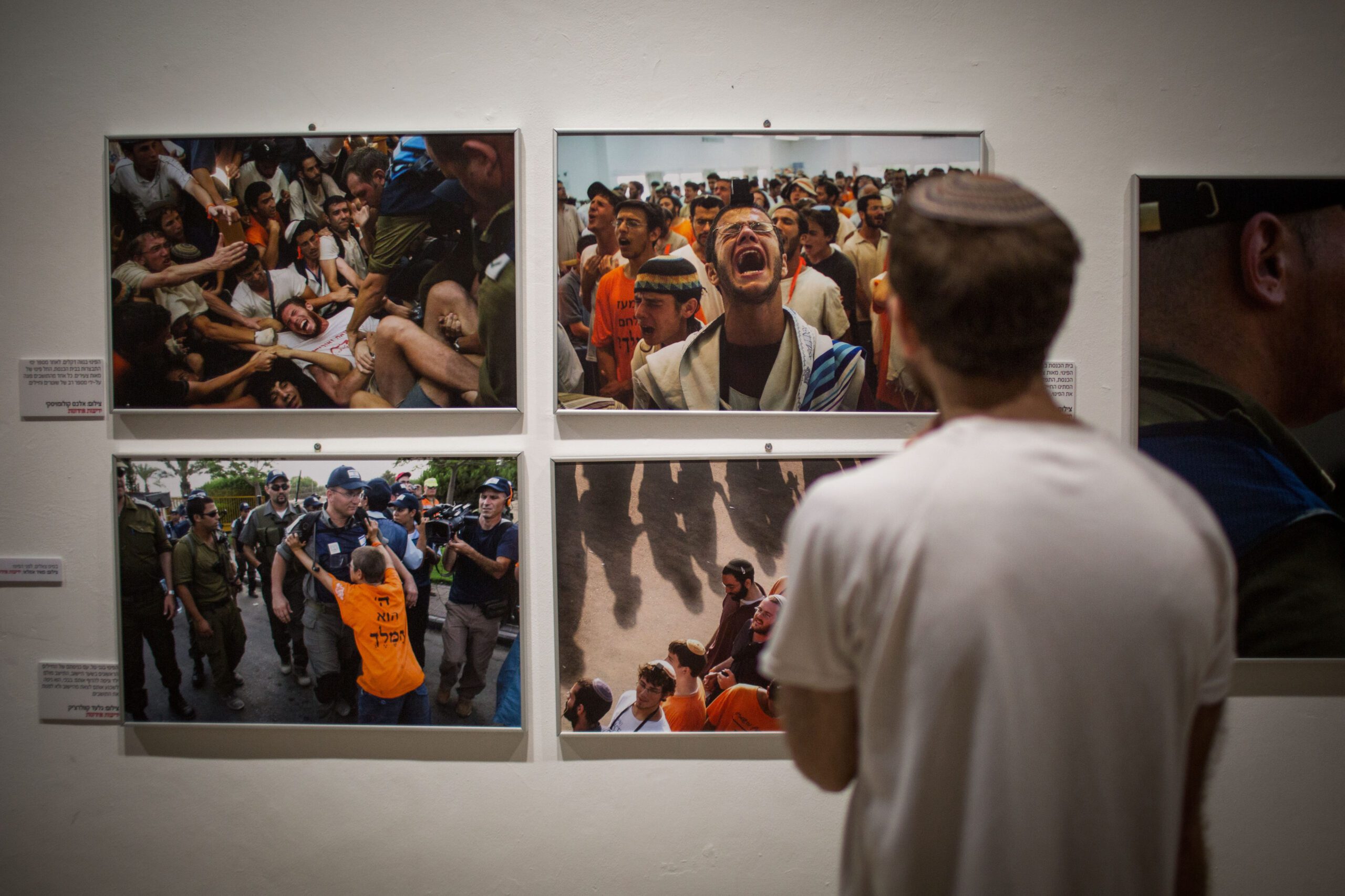 Israelis schauen sich die Ausstellung von Photographien in Jerusalems First Station an, die die Räumung des Siedlungsblocks von GuschKatif im Jahr 2005 dokumentieren. Die Photographien wurden von Photographen der israelischen Tageszeitung Jedi’ot Acharonot aufgenommen. 21. Juli 2015. (Hadas Parush/Flash90)