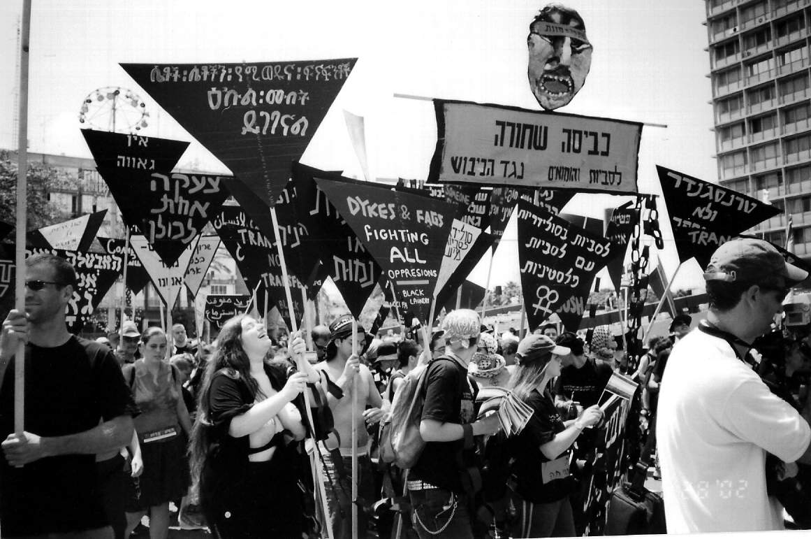 Blackwashing-Demonstration bei der Pride Parade, 2002. Auf den Schildern steht z.B. "Blackwashing - Lesben und Schwule gegen die Besatzung", "Lesben in Solidarität mit palästinensischen Lesben".