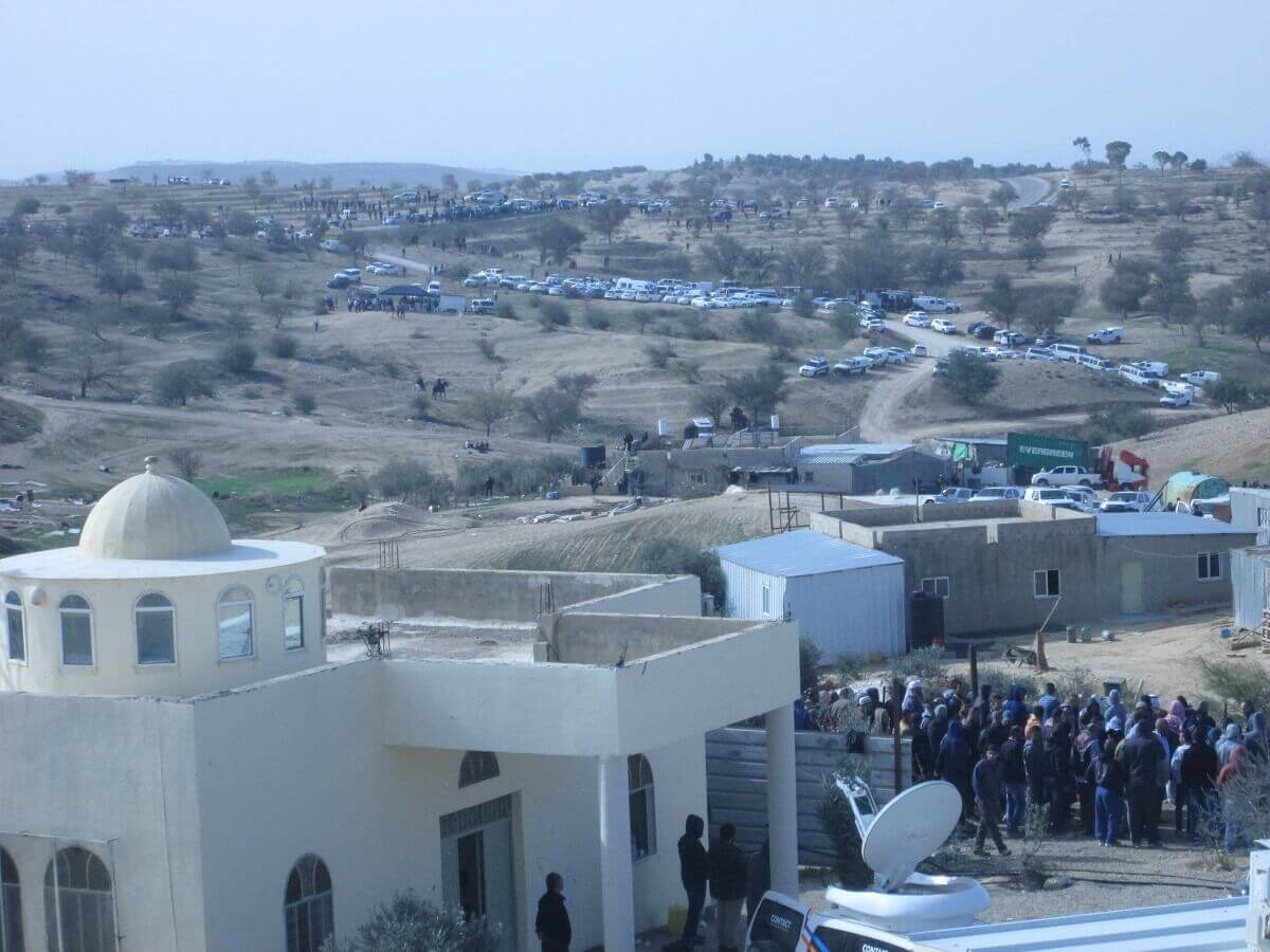 Die Polizei bringt die Dorfbewohner*innen in den Hof der Moschee und hält sie dort fest. Im Hintergrund: Dutzende von Polizeistreifenwagen, die in das Dorf gekommen sind. Foto: Jusawiruna Fotograf*innen Kollektiv