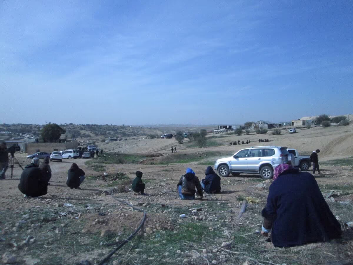 Die Dorfbewohner*innen sitzen auf der Erde, ihnen gegenüber die Einsatzkräfte der Polizei. Foto: Jusawiruna Fotograf*innen Kollektiv