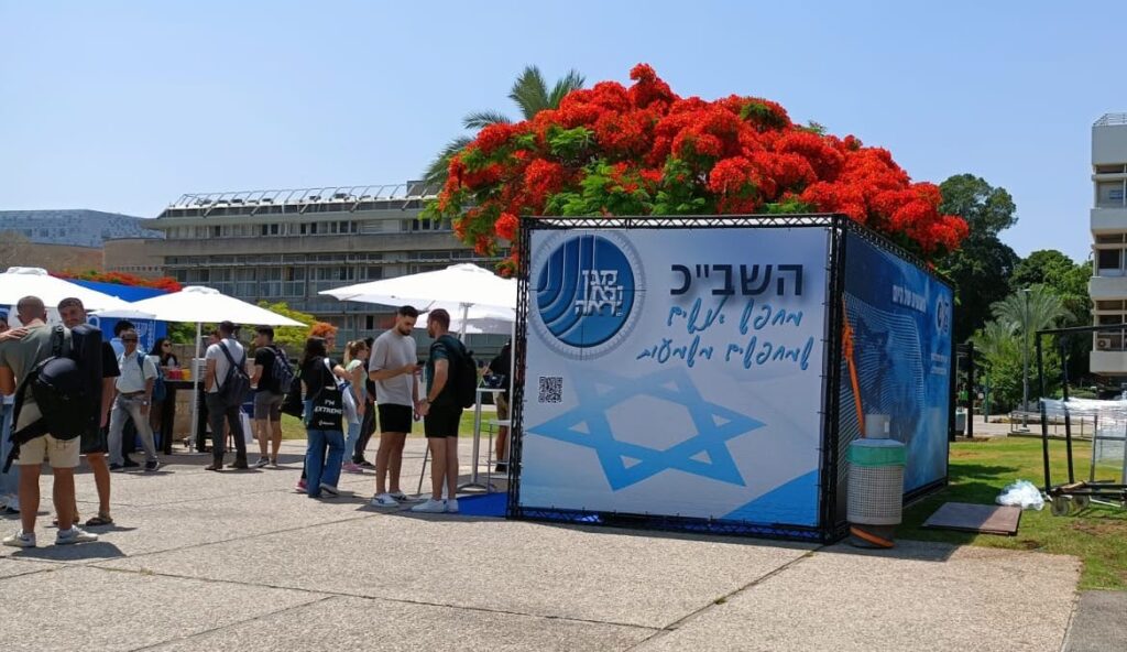 Recruitment booth for the Israeli Security Service (Shabak) at the job fair at Tel Aviv University, 2023. Photo: Nisi Peli. On the poster: The Shin Bet is looking for people who are searching for meaning